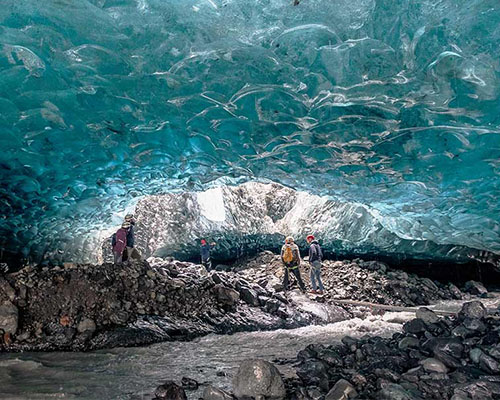 Four people inside a glacier in iceland.